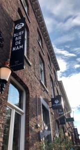 a brick building with a sign for a blue bee be man at Blief bie de Mam in Echt