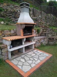 un horno de ladrillo sentado en un patio junto a una pared de piedra en Casona Angliru en Riosa