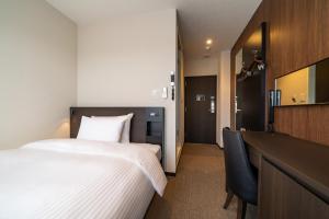 Goi Grand Hotel في Ichihara: غرفة في الفندق مع سرير ومكتب