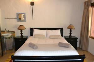 a bedroom with a large bed with two lamps and a sink at KweKwe Private Game Lodge in Marble Hall
