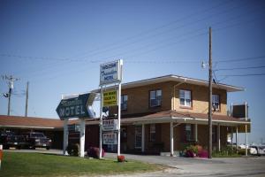 un edificio con carteles delante de un motel en Travelier Motel - Macon, en Macon
