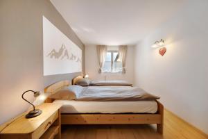 um quarto com uma cama e uma secretária de madeira em Residence Montebel Bilocale em Tesero