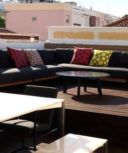 a couch and a coffee table on a balcony at Casa dos Retratos Faro in Faro