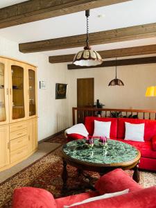 Ferienappartement Mimmi في باد لوتربرغ: غرفة معيشة مع أريكة حمراء وطاولة