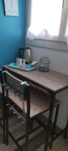 a wooden table in a room next to a window at 2 chambres côté plage in Hyères