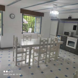 uma cozinha com mesa e cadeiras num quarto em Casa Rural El Amparuco em Treceño