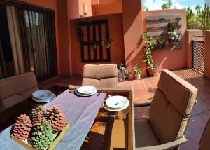 a patio with a table and chairs on a balcony at Alojamiento Apartamento Motril Playa Granada campo golf in Motril