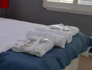 two towels sitting on top of a bed at Empress Tree Cottage with large hot tub in Poole