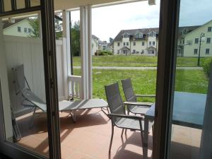 a patio with two chairs and a table on a porch at Dünenpark Binz - Fewos by Sander in Binz