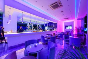 a bar in a restaurant with purple lighting at River Rock Hotel in Ayia Napa +24 photos