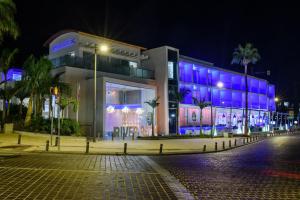 a building with blue lights on it at night at River Rock Hotel in Ayia Napa