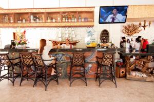 une femme assise à un bar dans un restaurant dans l'établissement Malapascua Legend Water Sports and Resort, à Malapascua