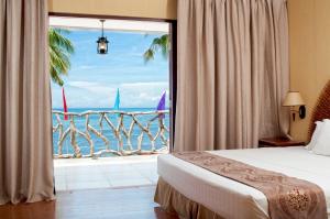 - une chambre avec une grande fenêtre donnant sur l'océan dans l'établissement Malapascua Legend Water Sports and Resort, à Malapascua 26 autres photos