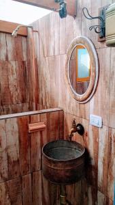 a wooden bathroom with a sink and a mirror at Casa de campo, surf, pesca y golf in Miramar