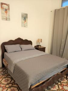 1 dormitorio con 1 cama y 1 mesa con lámpara en Villa Mosta en Mosta