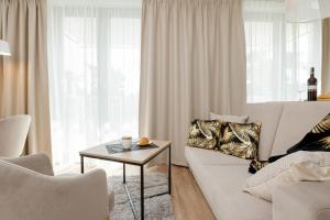 a living room with a white couch and a table at Apartamenty Jantaris by Renters in Mielno