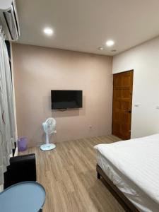 a bedroom with a bed and a tv on the wall at MiShi 85 Guest House in Lukang