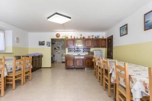 a kitchen with wooden tables and chairs in a room at Casa Vacanza Zambotti in Vermiglio
