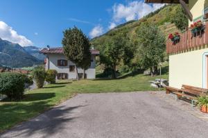 a road leading to a house with a bench at Casa Vacanza Zambotti in Vermiglio