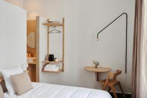 een slaapkamer met een wit bed en een tafel bij Edgar Guesthouse in Gent