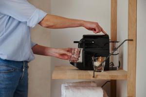 a man is holding a cup next to a toaster at Edgar Guesthouse in Ghent +17 photos
