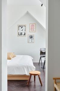 a bedroom with a bed and a wooden stool at Edgar Guesthouse in Ghent