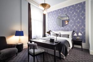 a room with a bed, chair, desk and a lamp at TORTUE HAMBURG - Schöner als die Fantasie in Hamburg
