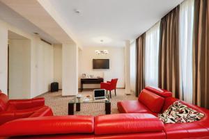 uma sala de estar com um sofá vermelho e uma mesa em Hotel Borowiecki em Łódź