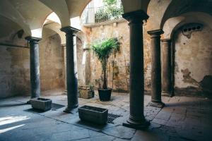 a courtyard with pillars and a potted plant in a building at Beautiful View in Bergamo