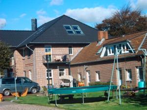 a house with a playground in front of it at "Höper Mittelhof" Ferienhaus Nr3 in Lemkendorf