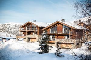 ein Haus im Schnee mit schneebedecktem Boden in der Unterkunft Chalet le Blue Moon in L'Alpe-d'Huez