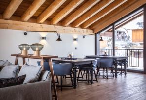 a dining room with tables and chairs and a balcony at Chalet le Blue Moon in L'Alpe-d'Huez