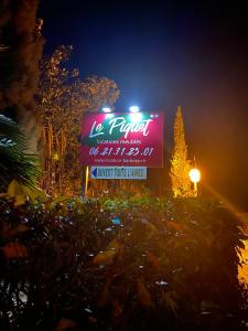 a sign for a restaurant with a neon sign at Le Piquet Résidence-Pavillon in Cazaubon