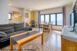 ein Wohnzimmer mit einem Sofa und einem Tisch in der Unterkunft Sobre de Granadella Haus 3-bis in Jávea