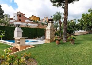 un patio trasero con piscina y jardín en Villa deluxe a Benalmadena, Espagne, en Benalmádena