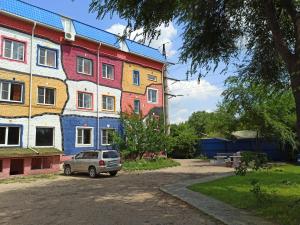 a car parked in front of a colorful building at Wasser отель, трасса M4 in Voronezh