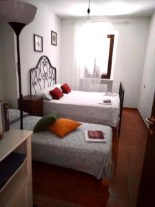 1 dormitorio con 2 camas y 1 silla con ventana en Bed&Breakfast La Ginestra en Abbateggio