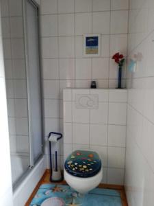 a small bathroom with a toilet with a blue seat at Ferienhaus ruhige Lage _ strandnah in Ueckeritz