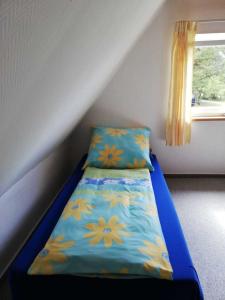 a small bedroom with a blue bed with flowers on it at Ferienhaus ruhige Lage _ strandnah in Ueckeritz