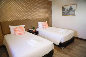 a hotel room with two beds and a picture on the wall at Parasol Inn Chiang Mai Old City in Chiang Mai