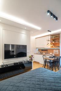 Una sala de estar con un televisor grande y una mesa. en Zvezda Lux, en Vrnjačka Banja