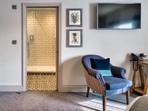 a living room with a blue chair and a television at The Wellington Arms in Heckfield