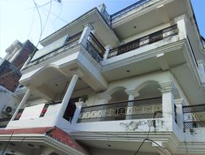 a large white building with balconies on it at Varuna Palace Near Mandir & Ghat's Varanasi in Varanasi