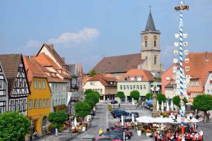 een stad met een klokkentoren en een straat met mensen bij Ferienwohnung AusZeit in Bad Neustadt an der Saale