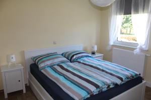 ein Schlafzimmer mit einem Bett mit zwei Kissen und einem Fenster in der Unterkunft Gästewohnung in Niesky in Niesky
