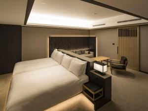 a bedroom with a large white bed and a desk at Portom International Hokkaido in Chitose