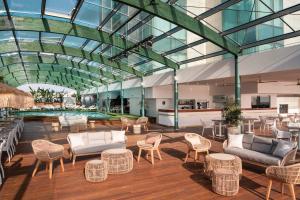 a lobby with chairs and tables and a pool at Arrecife Gran Hotel & Spa in Arrecife