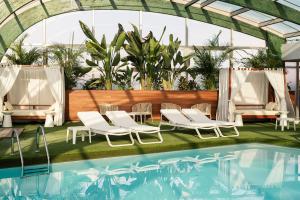 a group of chairs and a swimming pool at Arrecife Gran Hotel & Spa in Arrecife
