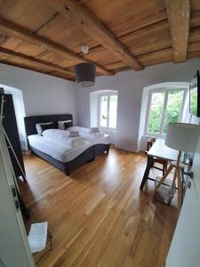 Schlafzimmer mit einem Bett und Holzboden in der Unterkunft Hotel und Restaurant zum Hirschen in Villigen