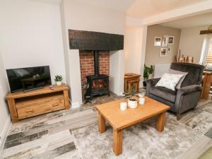 a living room with a fireplace and a television at 2 Morton Cottages in Preston